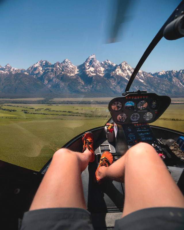 Feet selfie with the Grand Teton in the background in a helicopter. Photo credit David Rule