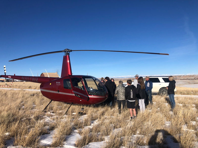 A family standing near Wind River Air's helicopter before a custom flight near Big Piney, WY. Photo credit. WRA