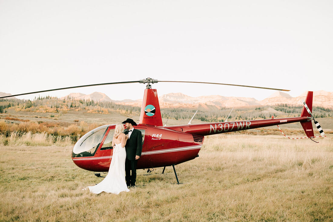 A man and a woman next to a helicopter.